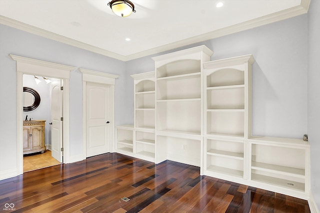 unfurnished bedroom featuring connected bathroom, ornamental molding, and hardwood / wood-style flooring