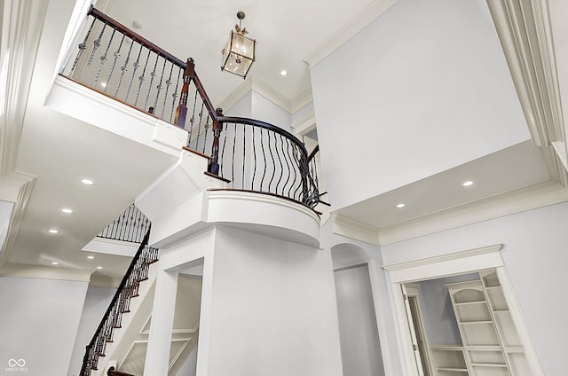 stairway featuring a high ceiling and ornamental molding