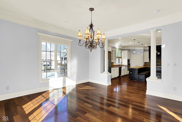 dining area featuring dark wood-type flooring, ornamental molding, and a notable chandelier