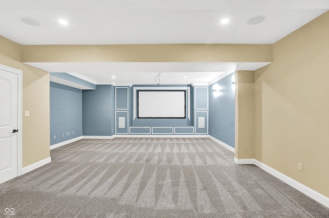 cinema room featuring crown molding and light colored carpet