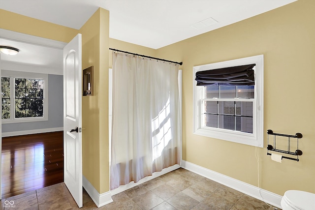 interior space featuring tile patterned floors and toilet