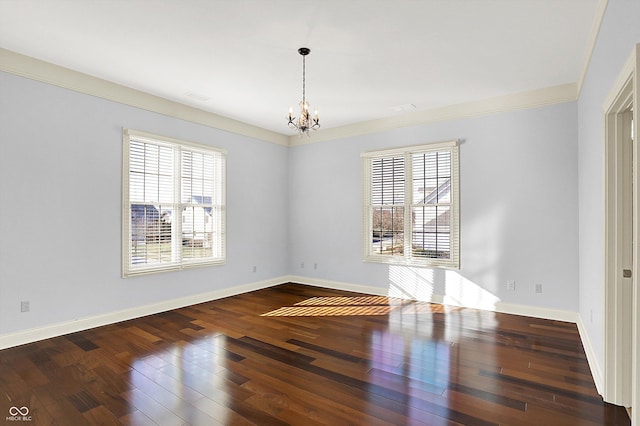 unfurnished room featuring plenty of natural light, crown molding, dark wood-type flooring, and a chandelier