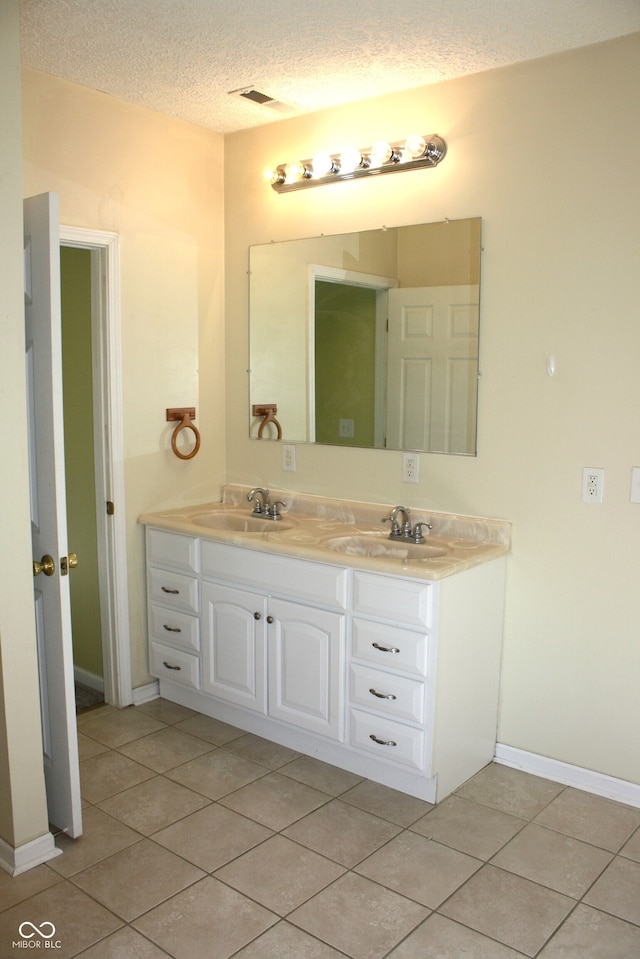 bathroom featuring tile patterned floors, vanity, and a textured ceiling