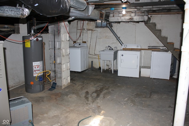 basement with water heater, washer and clothes dryer, and sink