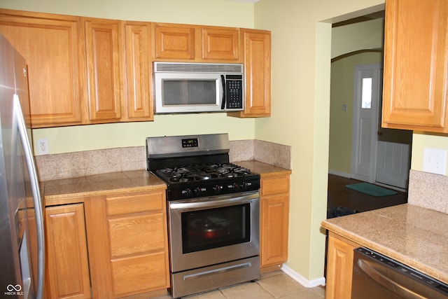 kitchen with light tile patterned floors and appliances with stainless steel finishes