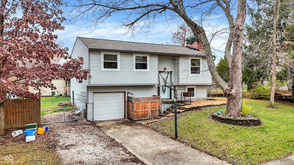 split foyer home with a garage and a front yard