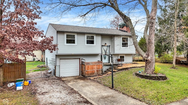 split foyer home with a garage and a front yard