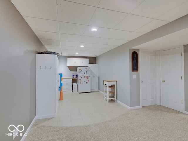 interior space featuring a paneled ceiling and light colored carpet