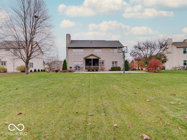 back of property with a yard and a sunroom