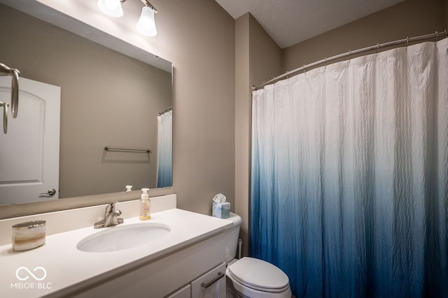 bathroom featuring a textured ceiling, vanity, and toilet