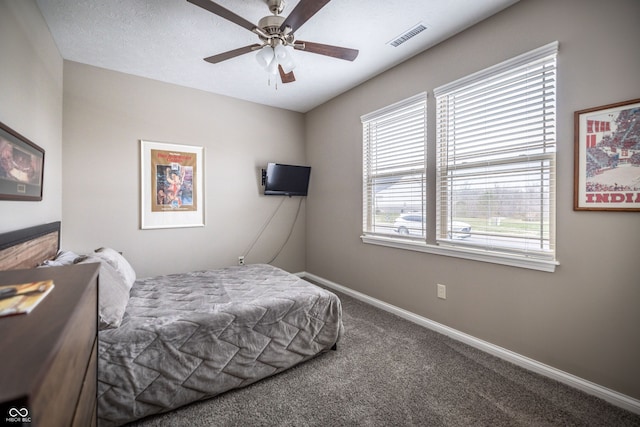 carpeted bedroom with a textured ceiling and ceiling fan