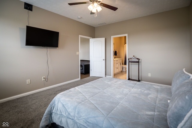 carpeted bedroom featuring ensuite bath, ceiling fan, and a textured ceiling