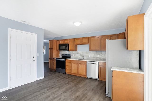 kitchen featuring backsplash, sink, stainless steel appliances, and hardwood / wood-style flooring