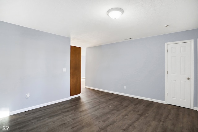 unfurnished room featuring dark wood-type flooring