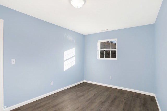 empty room with dark hardwood / wood-style flooring