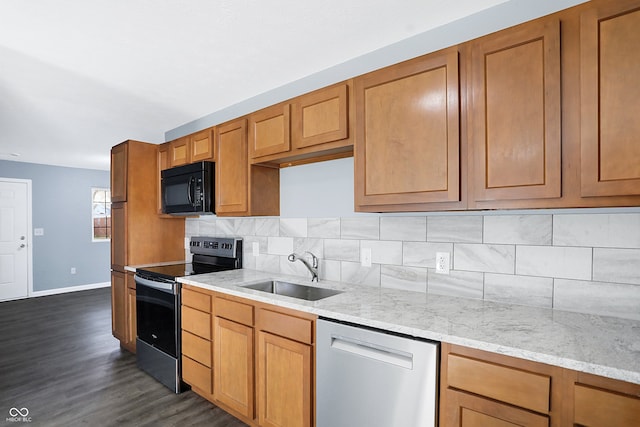 kitchen with appliances with stainless steel finishes, tasteful backsplash, light stone counters, sink, and dark hardwood / wood-style floors