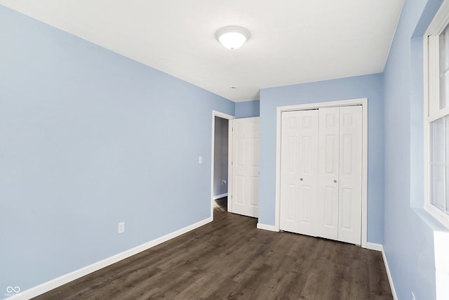 unfurnished bedroom featuring dark hardwood / wood-style floors and a closet