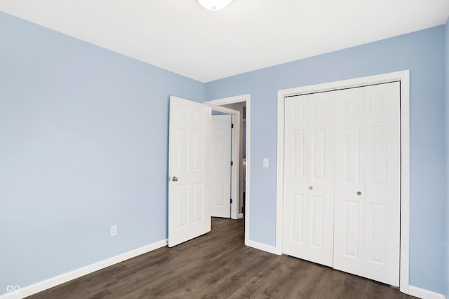 unfurnished bedroom featuring dark hardwood / wood-style flooring and a closet