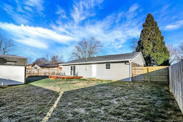 back of house with a lawn, a storage shed, and a deck