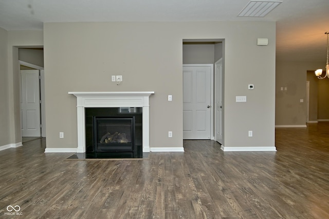 17345 Northam Dr, Westfield, IN 46074 - unfurnished living room featuring a fireplace with flush hearth, wood finished floors, baseboards, and a notable chandelier