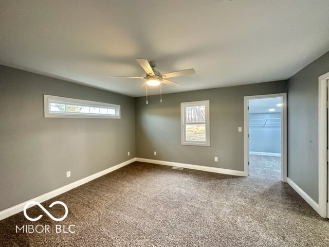 empty room featuring carpet flooring and ceiling fan