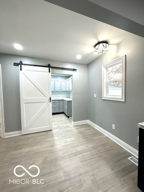 interior space featuring a barn door and light wood-type flooring