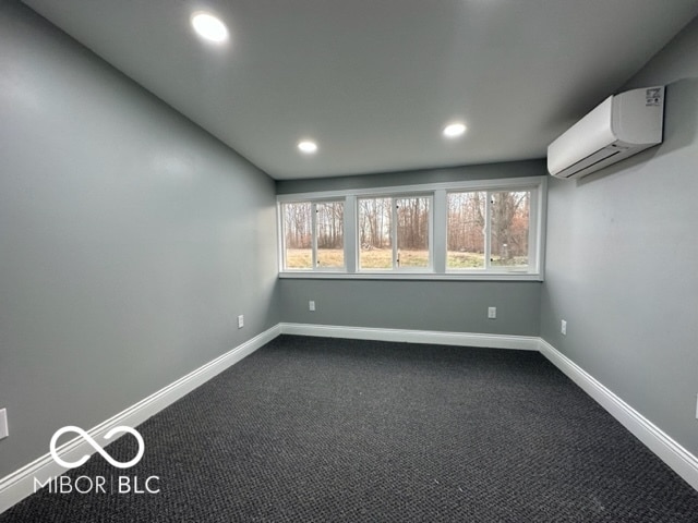 empty room with carpet flooring and an AC wall unit