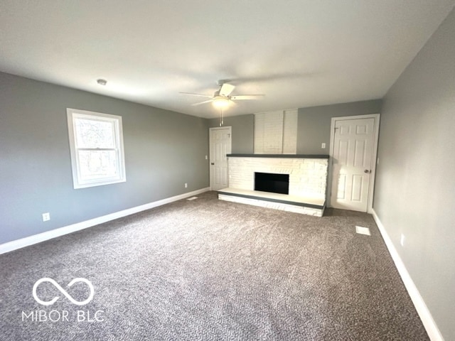 unfurnished living room with carpet flooring, ceiling fan, and a brick fireplace