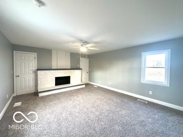 unfurnished living room with a fireplace, carpet flooring, and ceiling fan