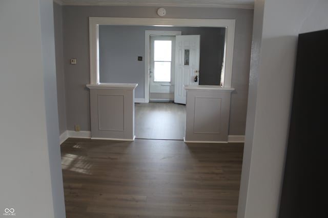 entrance foyer with ornamental molding and dark wood-type flooring