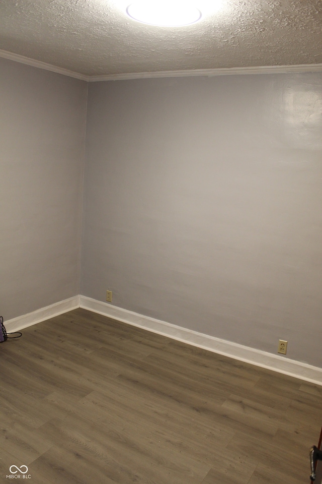 unfurnished room with a textured ceiling, dark hardwood / wood-style floors, and ornamental molding