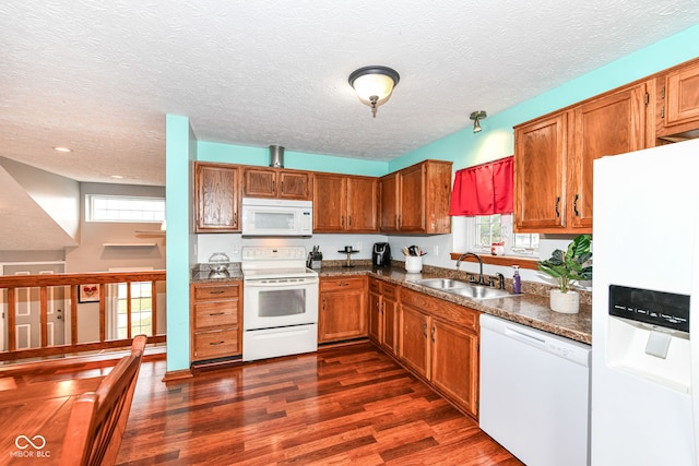 kitchen featuring a textured ceiling, white appliances, dark wood-type flooring, and sink