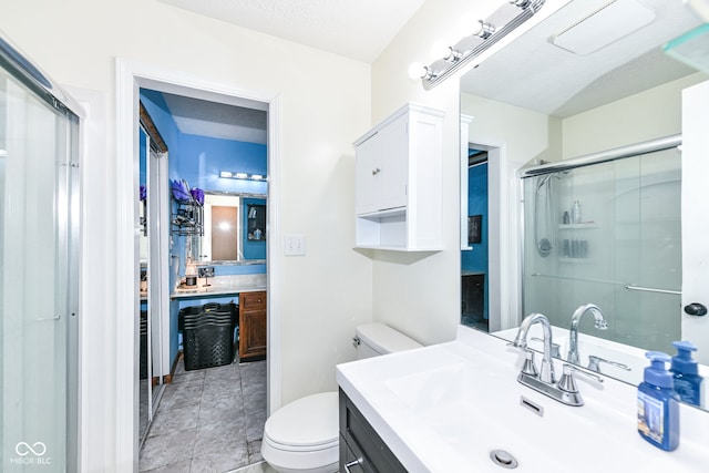 bathroom with toilet, an enclosed shower, a textured ceiling, and vanity