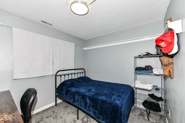 bedroom with a textured ceiling and carpet floors