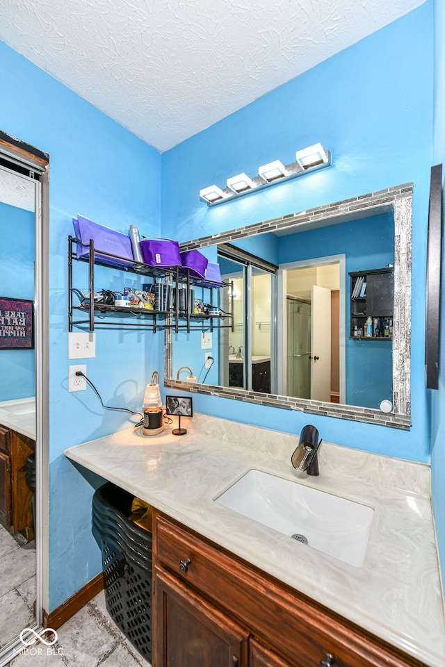 bathroom featuring a textured ceiling and vanity