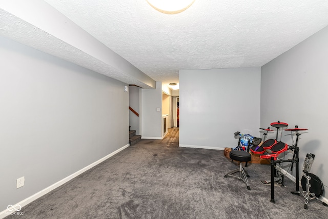 playroom with a textured ceiling and dark colored carpet