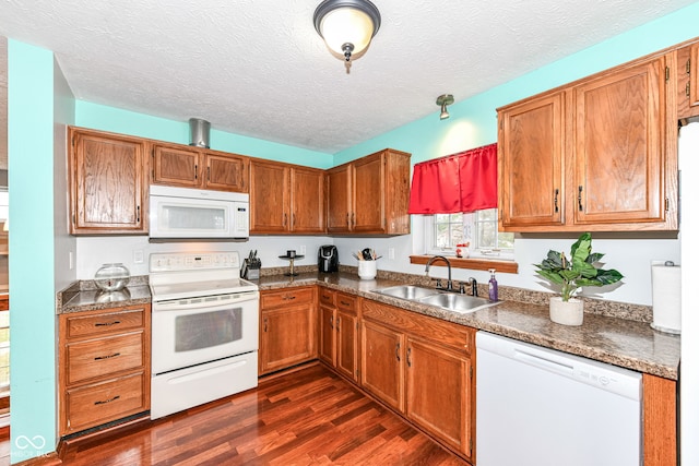 kitchen with a textured ceiling, sink, dark hardwood / wood-style floors, and white appliances