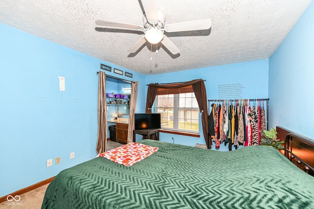 carpeted bedroom featuring a textured ceiling and ceiling fan