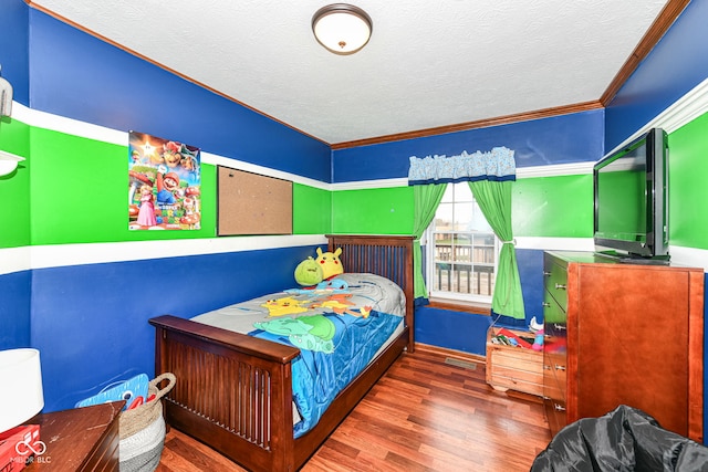 bedroom with a textured ceiling, dark hardwood / wood-style floors, and ornamental molding