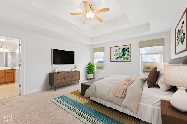 bedroom with ceiling fan, light carpet, connected bathroom, and multiple windows