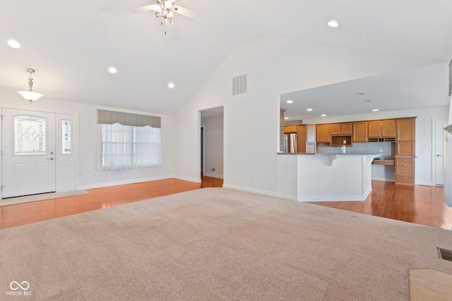 unfurnished living room with high vaulted ceiling, light hardwood / wood-style flooring, and ceiling fan