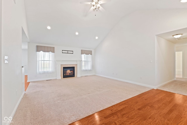 unfurnished living room with plenty of natural light, vaulted ceiling, ceiling fan, and light hardwood / wood-style flooring