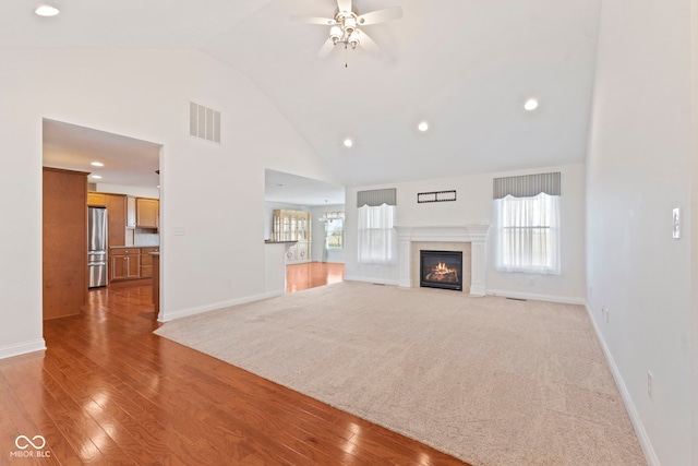 unfurnished living room featuring ceiling fan, high vaulted ceiling, and light hardwood / wood-style flooring