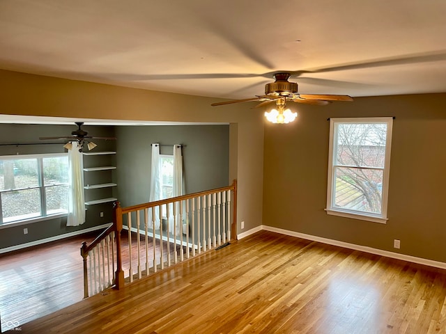 empty room with ceiling fan and light wood-type flooring