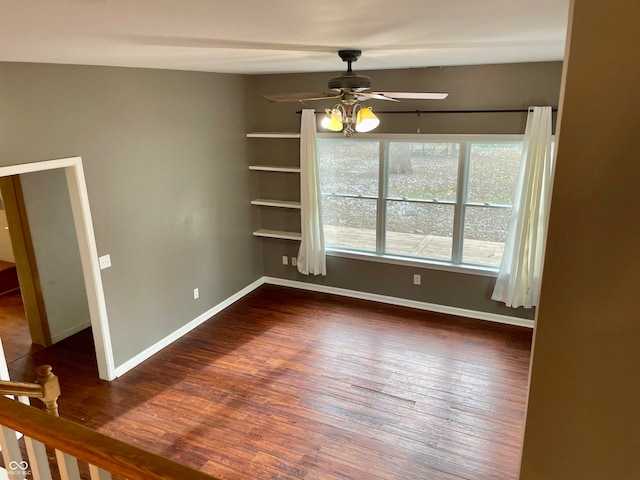 unfurnished room with dark hardwood / wood-style flooring and ceiling fan