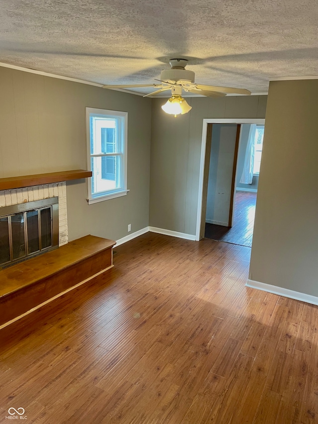 unfurnished living room featuring ceiling fan, hardwood / wood-style floors, crown molding, and a textured ceiling