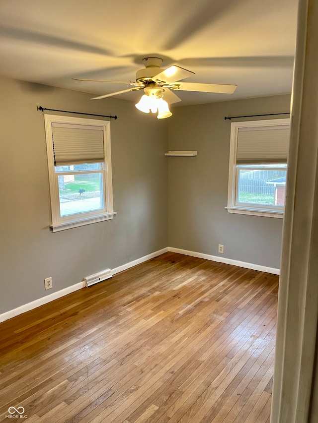 empty room with ceiling fan, a healthy amount of sunlight, and light hardwood / wood-style flooring