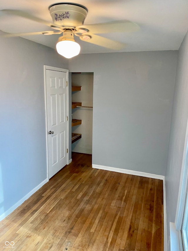 empty room with ceiling fan and hardwood / wood-style floors