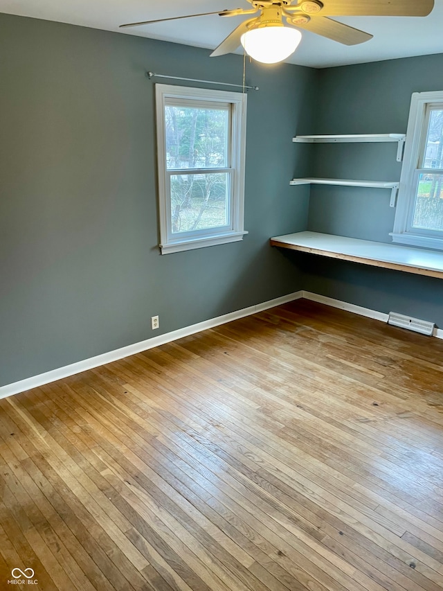 interior space featuring ceiling fan, light hardwood / wood-style floors, and multiple windows