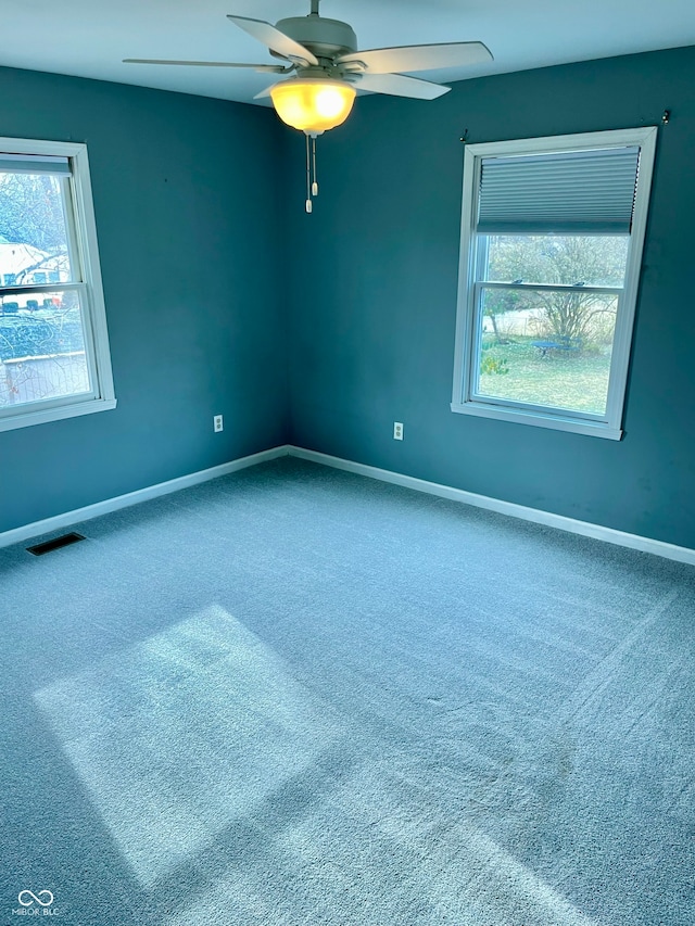 spare room featuring carpet floors, a wealth of natural light, and ceiling fan